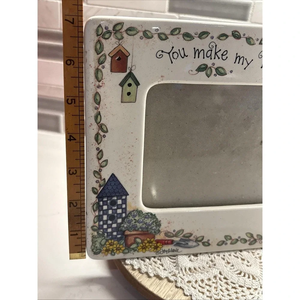 hand-painted ceramic picture frame featuring a garden theme with birdhouses.